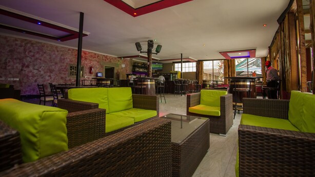 A spacious lobby with wicker furniture and a bar area. - Balis Best Bar and Resort (Nairobi)