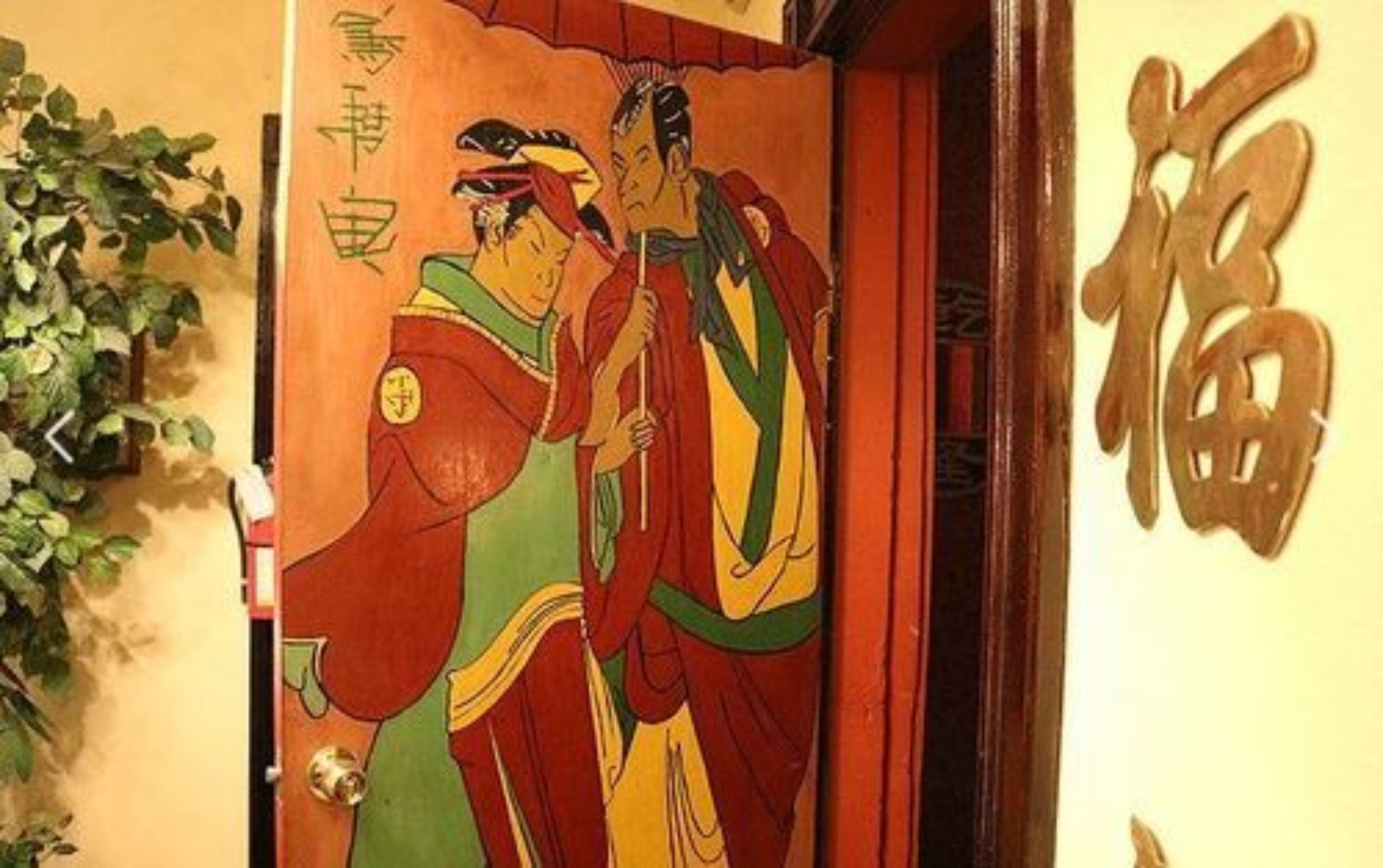 A traditional Japanese room with tatami flooring, a shoji screen door, and a hanging scroll with calligraphy.