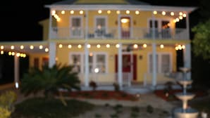 A two-story house with a balcony and string lights. - The Wayward Traveler's Inn (Mims)