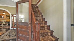 A wooden staircase with ornate carpeted steps leading to a landing. - The Wayward Traveler's Inn (Mims)