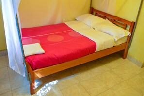 A single bed with a red and white bedspread, wooden headboard, and a white pillow. - West Park (Nairobi)