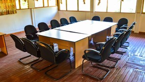 A conference room with a rectangular table surrounded by black chairs. - West Park (Nairobi)