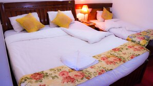 Una habitación de hotel con una cama grande, dos mesitas de noche y una mesita de noche con lámpara.