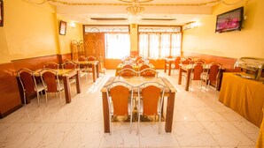 A banquet hall with multiple tables and chairs, a chandelier, and a television on the wall. - Shamz Hotel Isiolo (Isiolo)