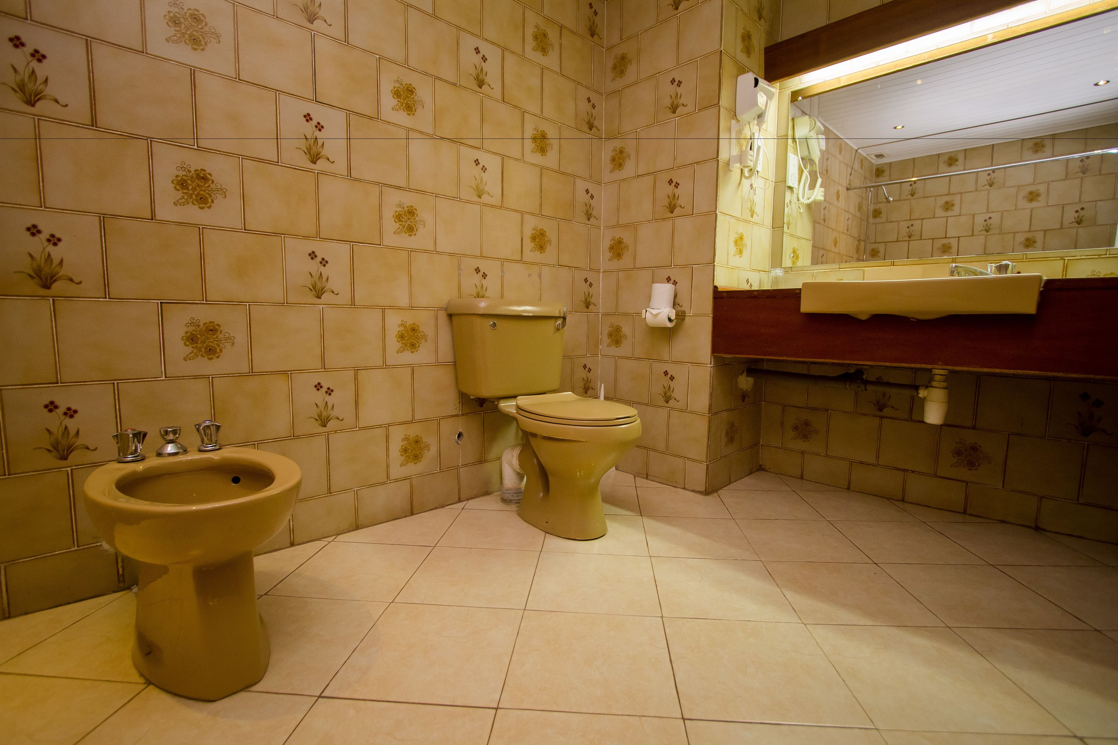 A bathroom with a toilet, bidet, and sink.