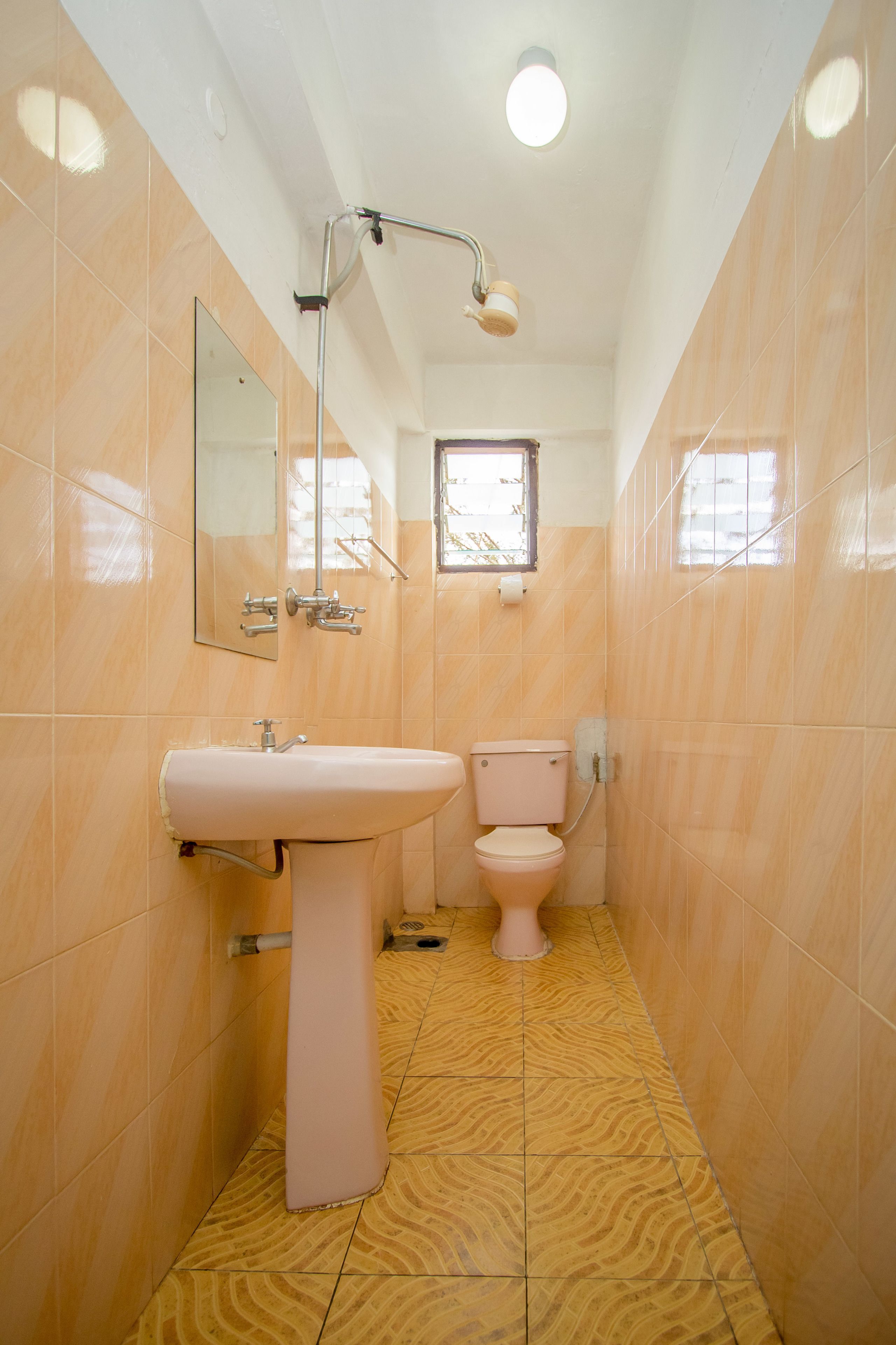 Un baño con lavamanos, inodoro y espejo.