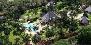 A resort with multiple buildings, a swimming pool, and lush greenery. - Sunset Villa Diani (Diani Beach)