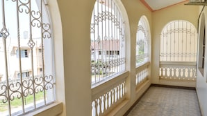 A corridor with arched windows and metal railings, leading to a balcony area. - Platinum Hotel (Mombasa)