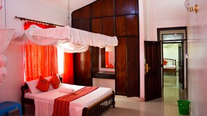 A bedroom with a bed, curtains, a wardrobe, and a mirror. - Sanana Conference Center and Holiday Resort (Mombasa)