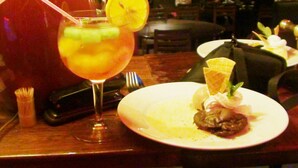 Una mesa de comedor con una copa de cóctel, un plato de postre y un tenedor.