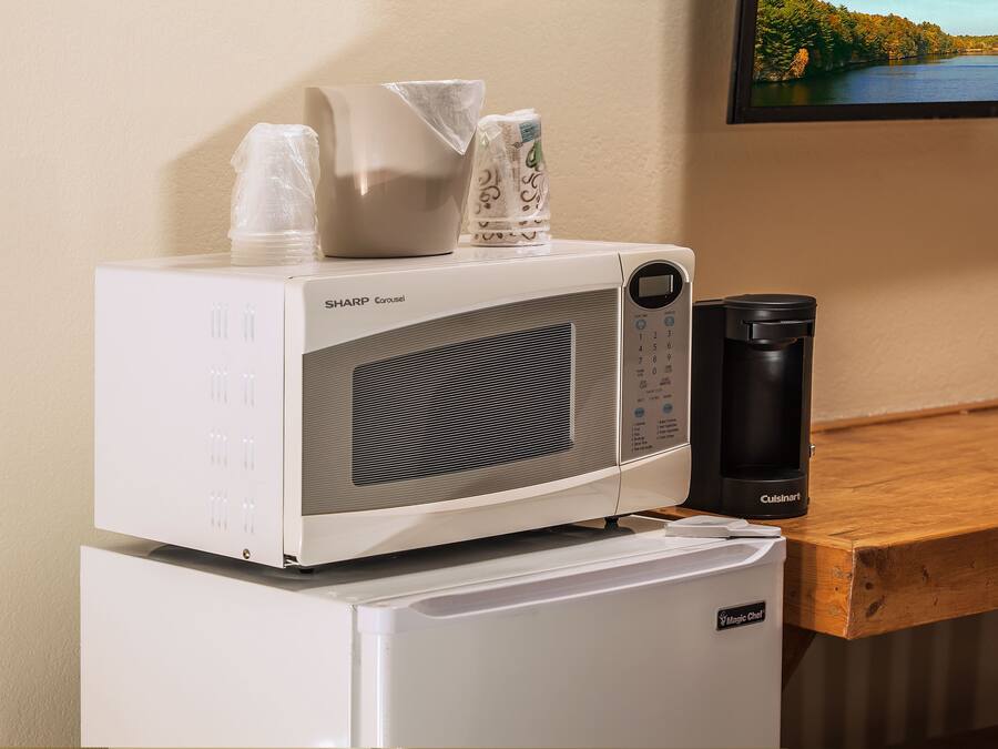 Un four à micro-ondes avec une machine à café et un réfrigérateur.