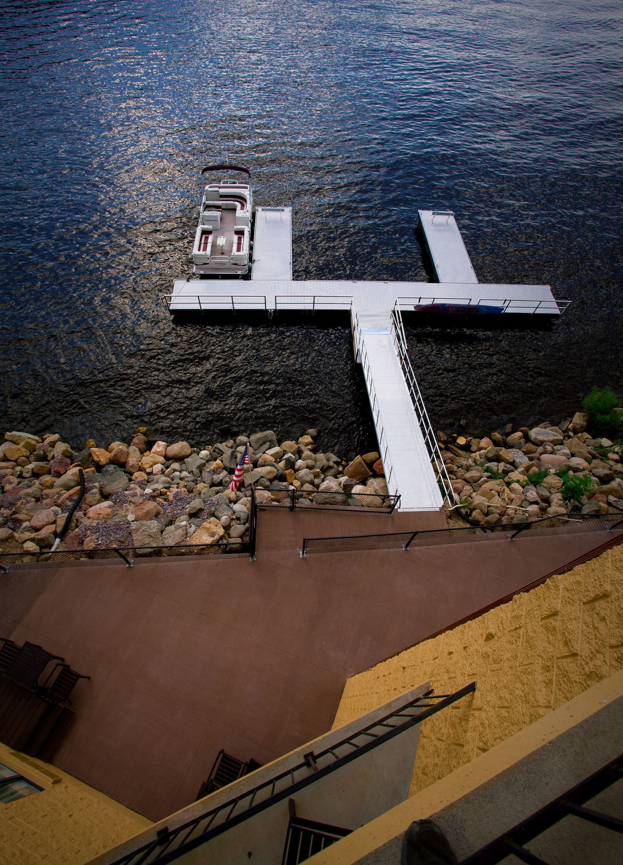 A pier extending into a body of water with a boat docked at the end.