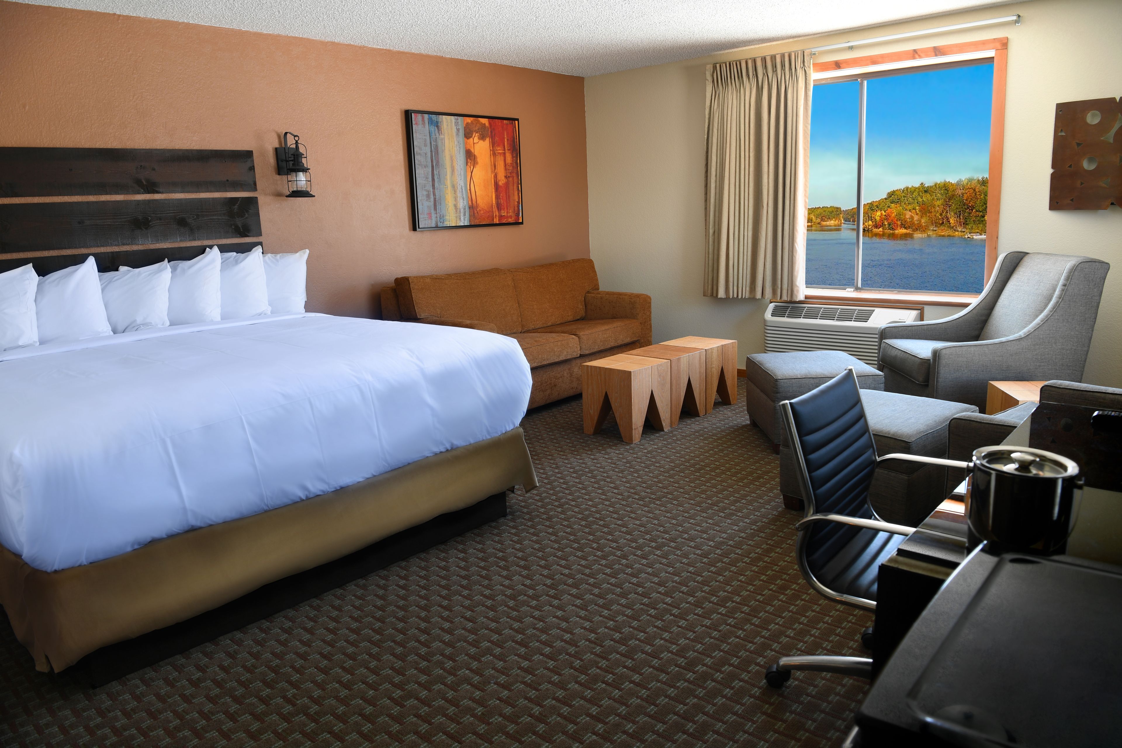Une chambre d’hôtel avec un grand lit, un canapé, un bureau et une chaise.