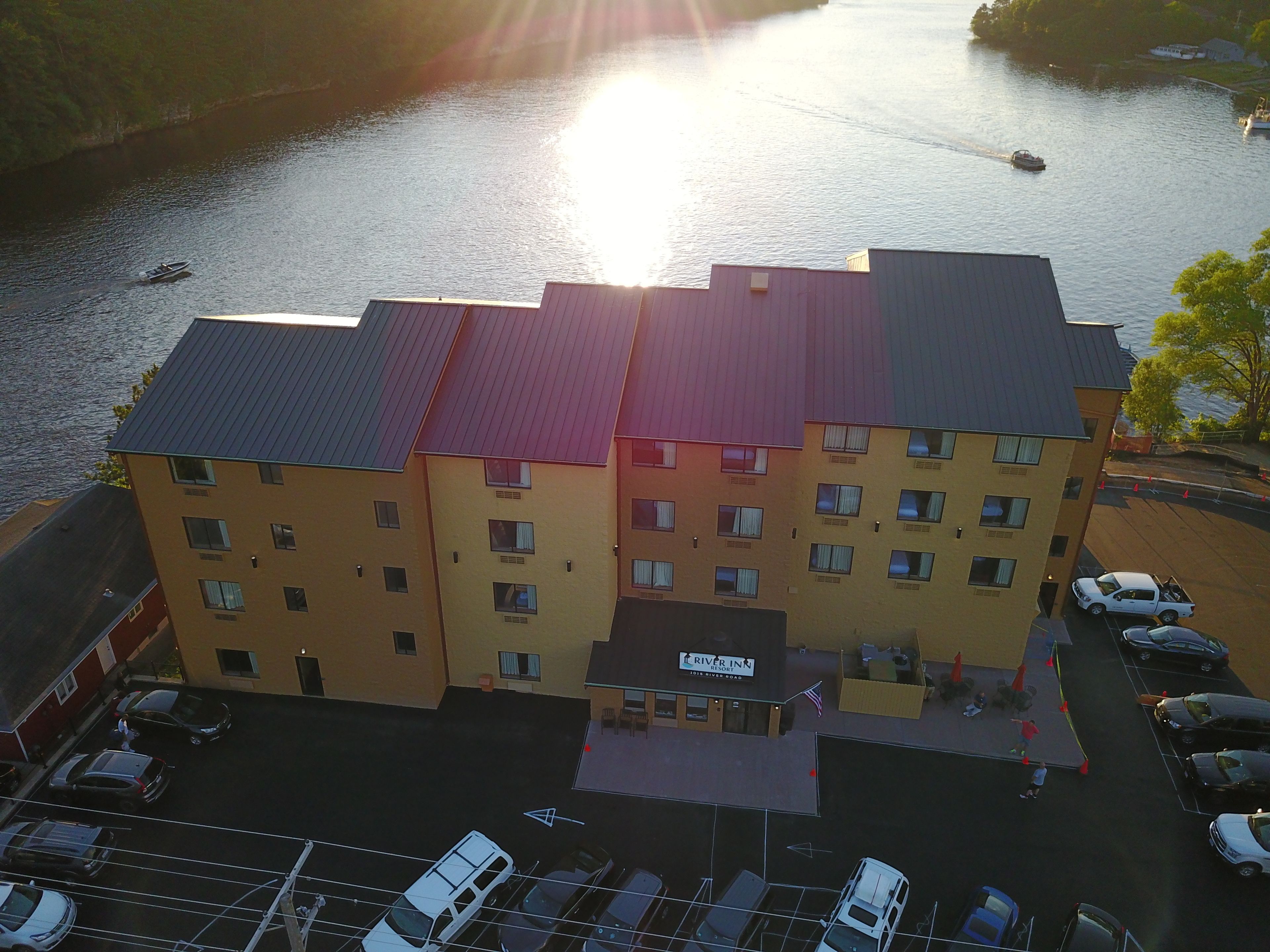A multi-story hotel with a flat roof and a parking lot in front.