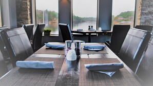A dining table set with a pitcher, salt and pepper shakers, and folded napkins.