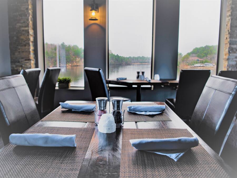 A dining table set with a pitcher, salt and pepper shakers, and folded napkins.