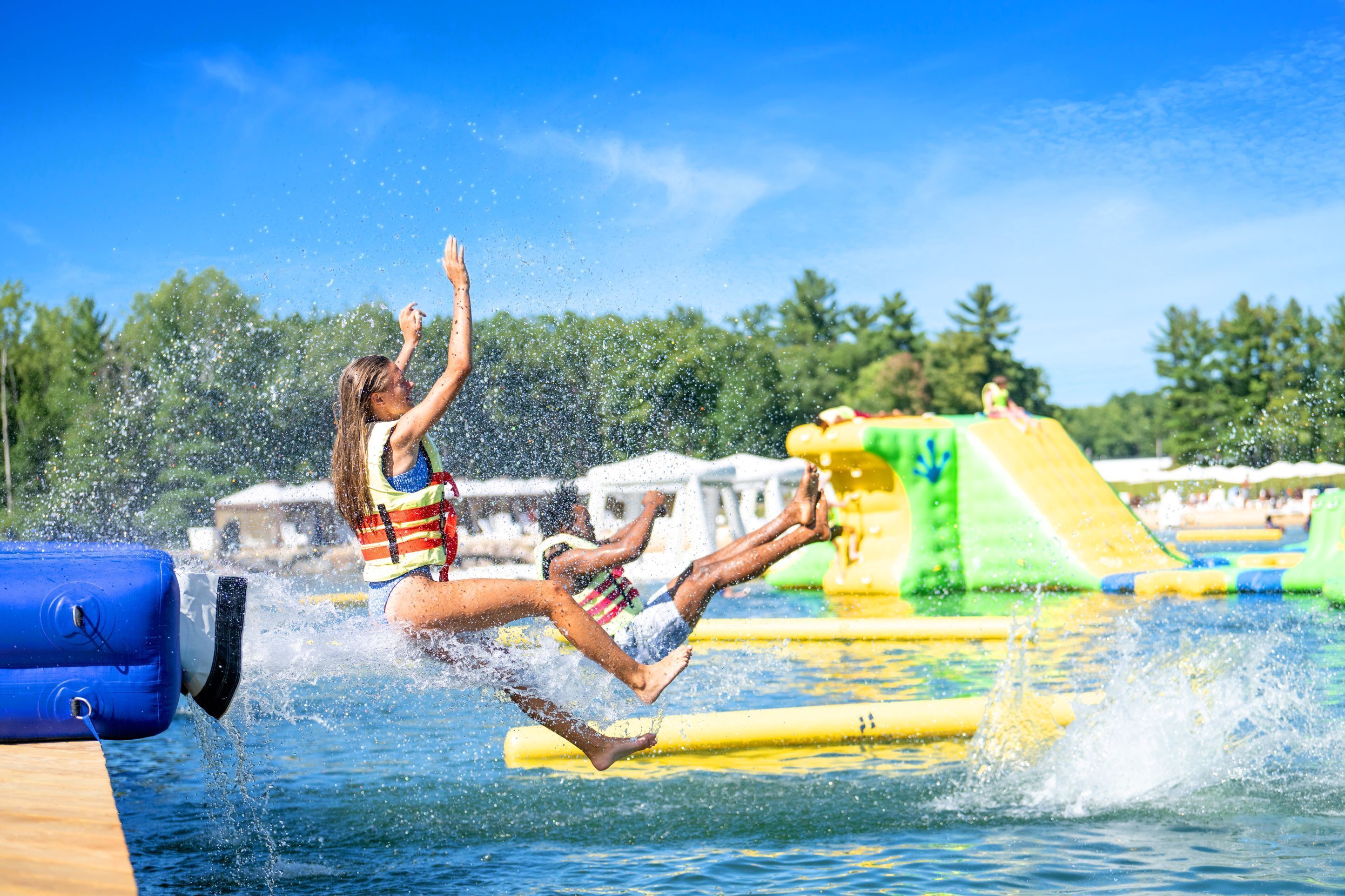 Un parc aquatique avec des toboggans gonflables et une piscine.