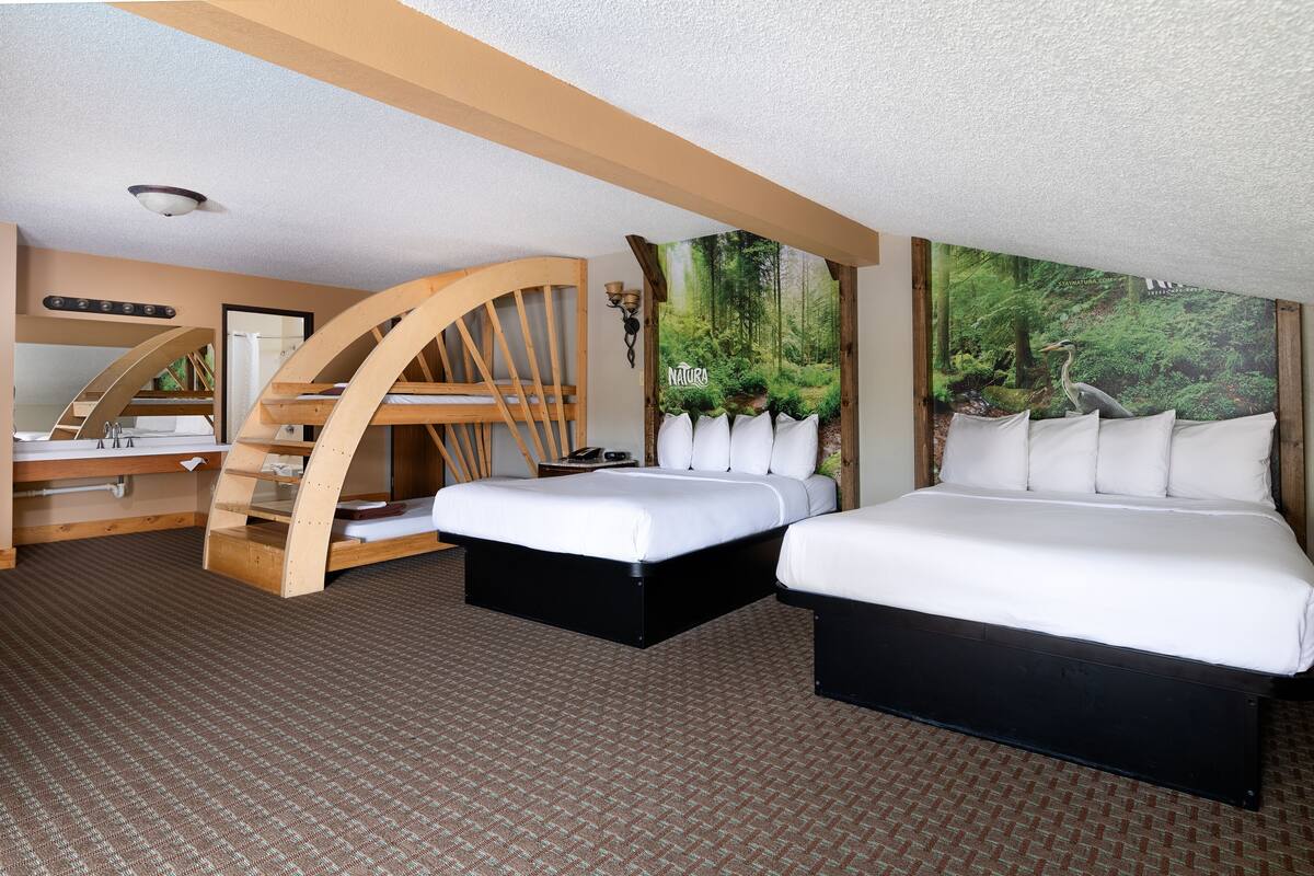 A bedroom with a bed, a desk, and a curved wooden chair.