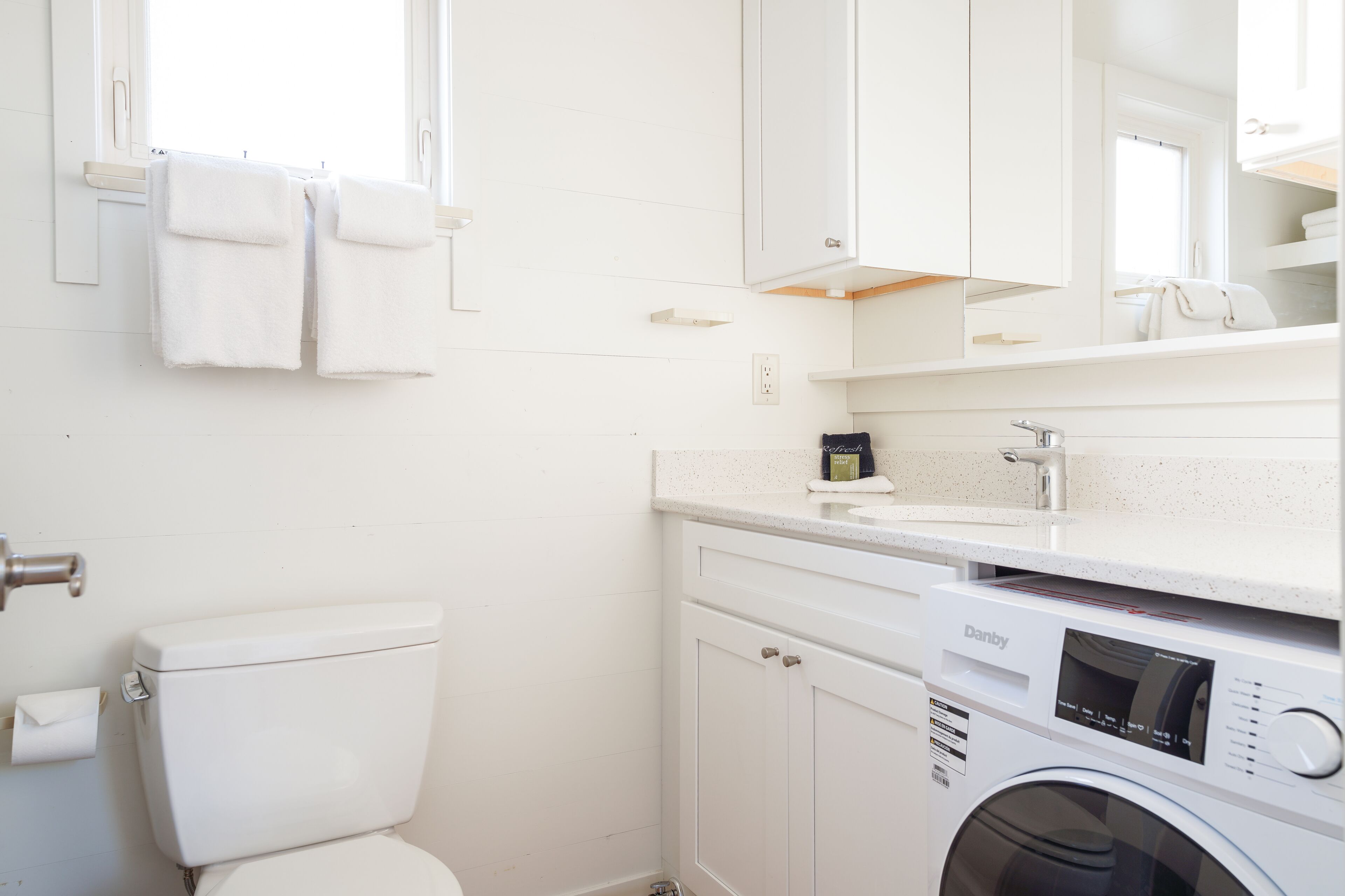 Un baño moderno y limpio con inodoro, lavadora y lavamanos.