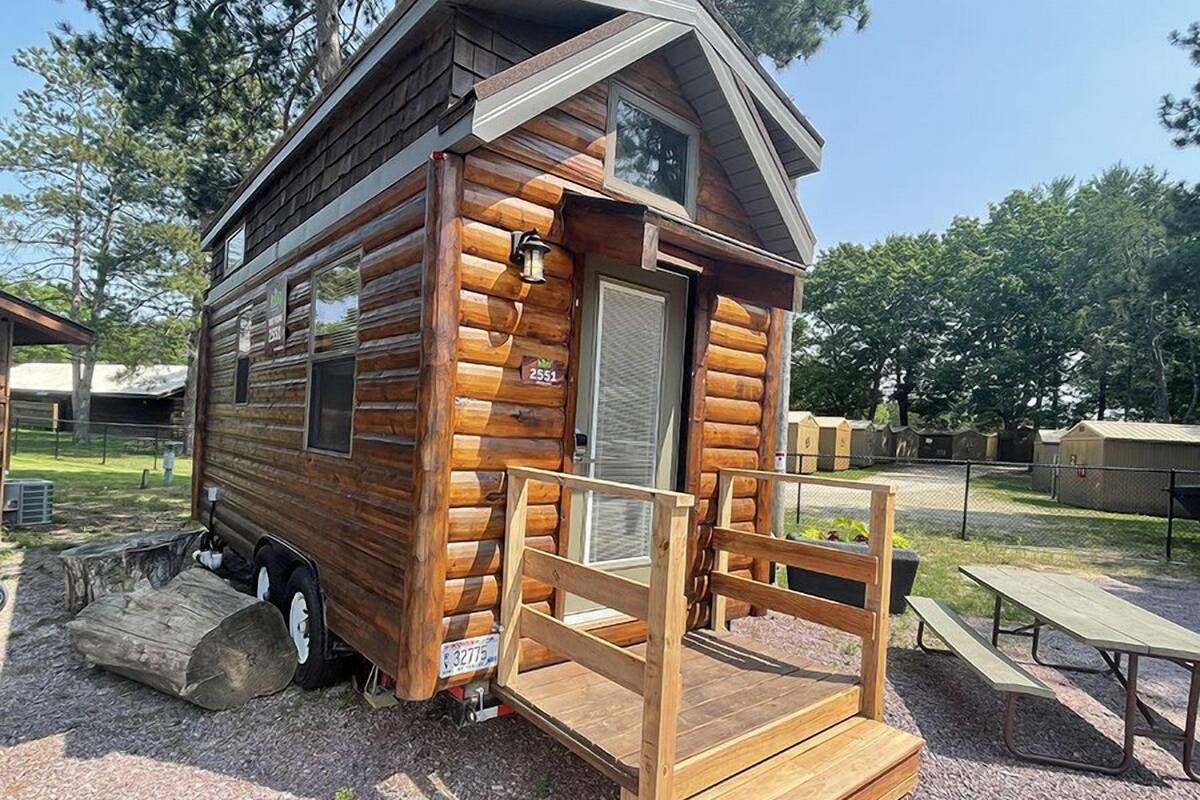 A small wooden cabin with a porch and a picnic table.