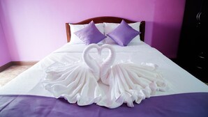 A bed with a purple headboard, white bedding, and two purple pillows. - Sweet Dreams Hometel (Krabi)