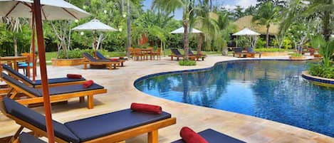 A poolside area with lounge chairs and umbrellas.