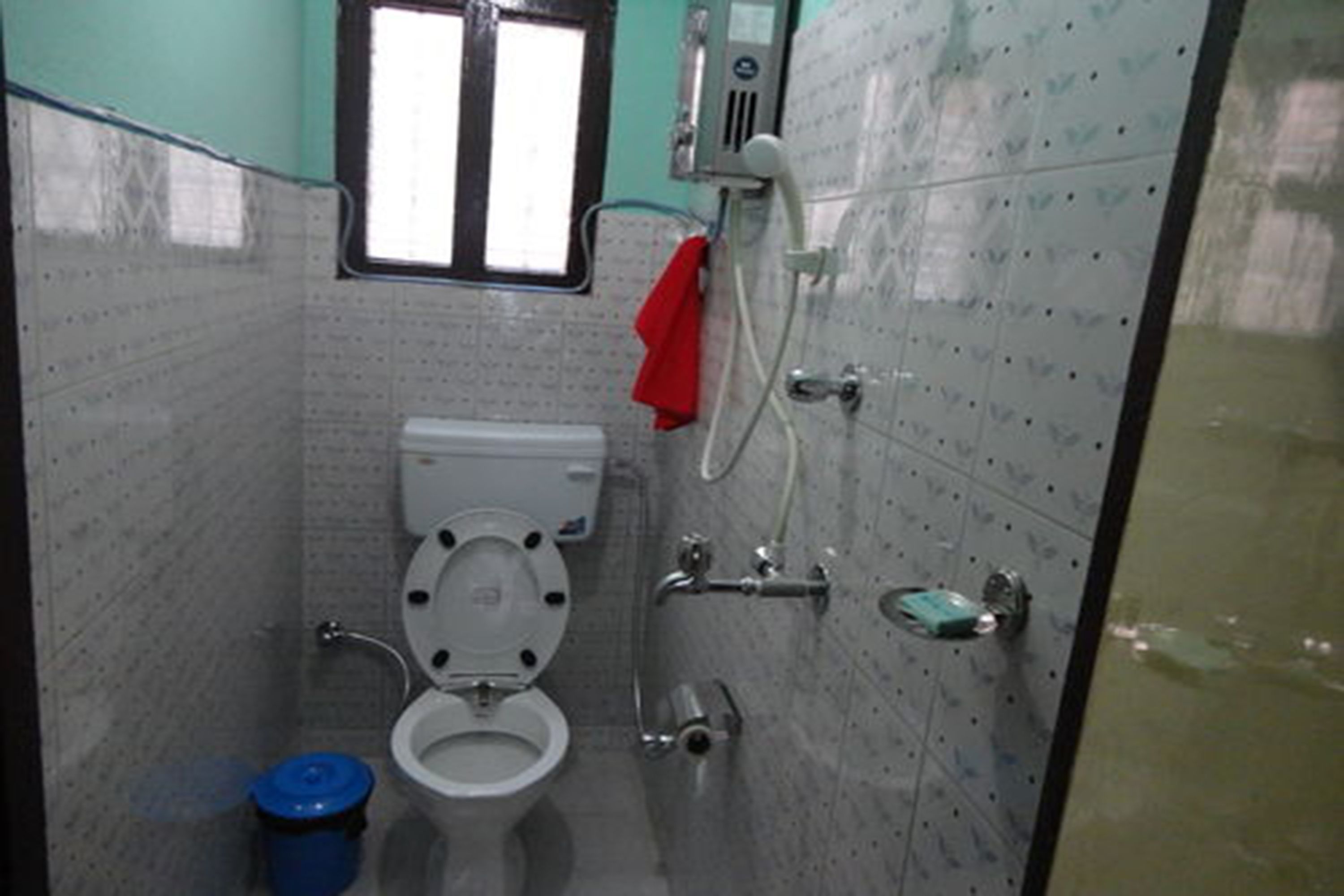 A small, compact bathroom with a toilet, bidet, and shower.