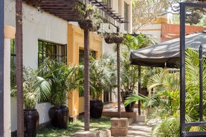 A courtyard with potted plants, a covered seating area, and a staircase leading to an upper level. - Capital Heights Hotel (Nairobi)