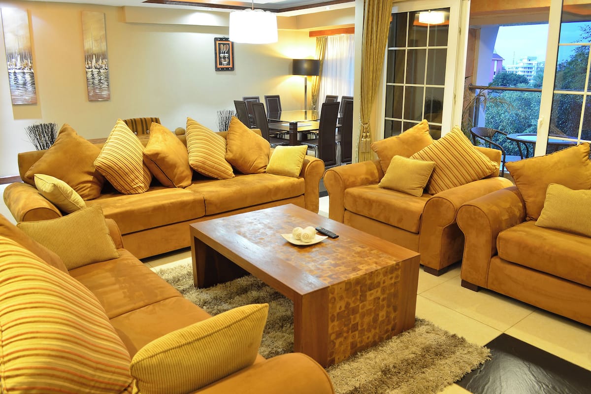A living room with two sofas, a coffee table, and a dining table with chairs.
