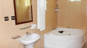 A bathroom with a sink, a mirror, a shower, and a bathtub. - Classic Hotel Limited (Kigali)