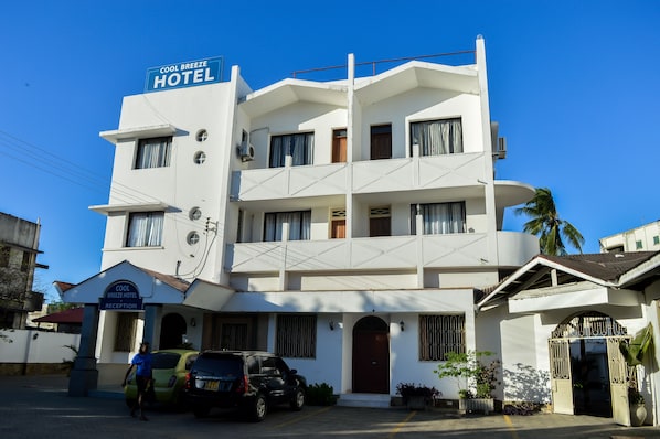 A multi-story hotel with a reception area and a parking lot.