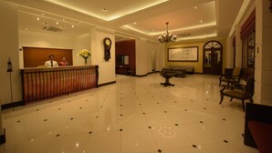A spacious lobby with a polished floor, a reception desk, a chandelier, and seating areas. - Hotel Nippon Colombo (Colombo)