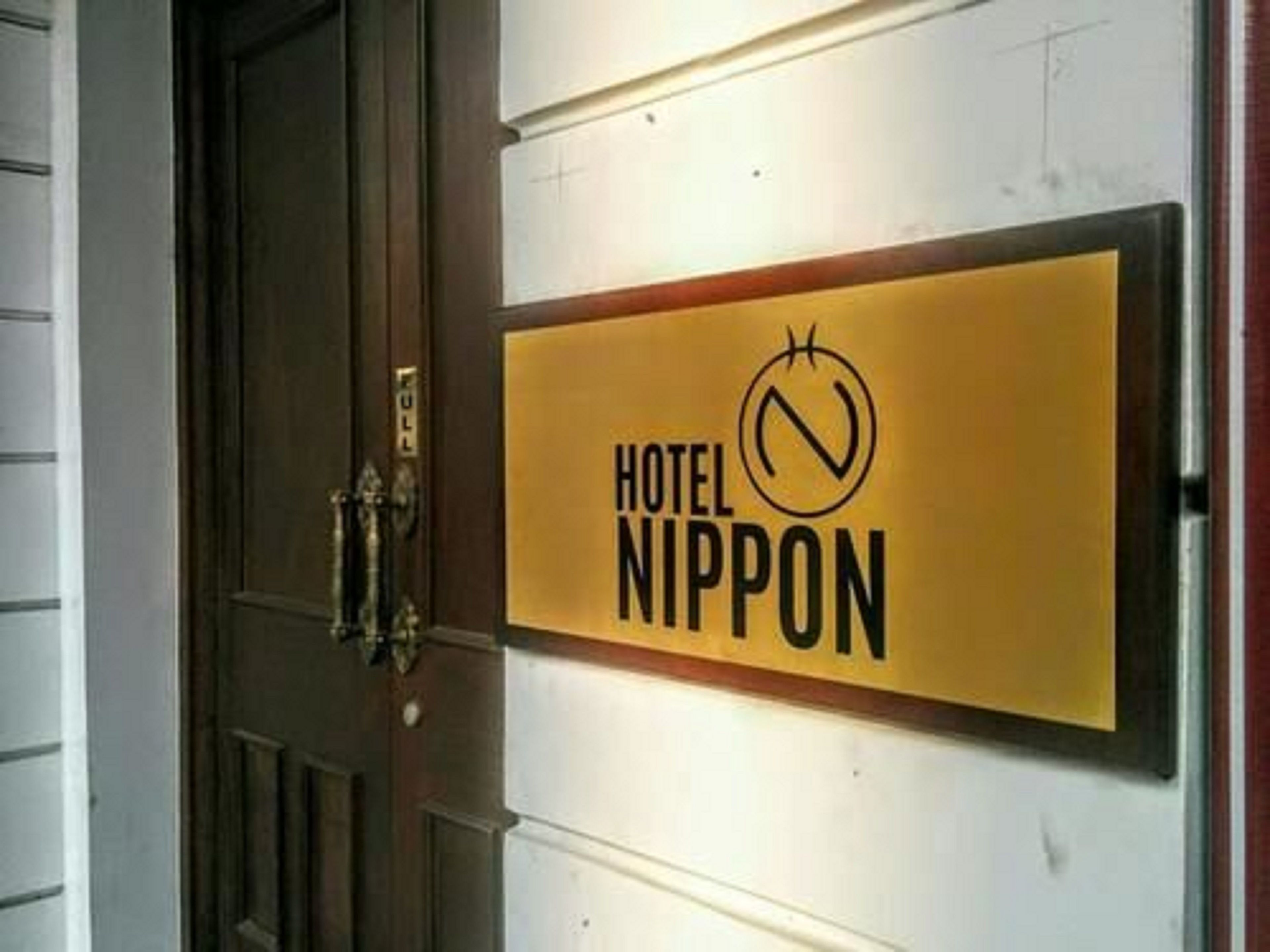 Un letrero de hotel con el nombre "HOTEL NIPPON" y un símbolo de prohibido.