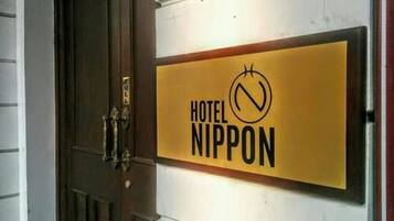 Un letrero de hotel con el nombre "HOTEL NIPPON" y un símbolo de prohibido.