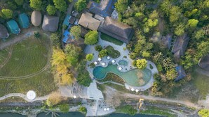 Vista aérea de un resort con varias edificaciones, una piscina grande y una zona de playa.