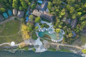Vista aérea de un resort con varias edificaciones, una piscina grande y una zona de playa.