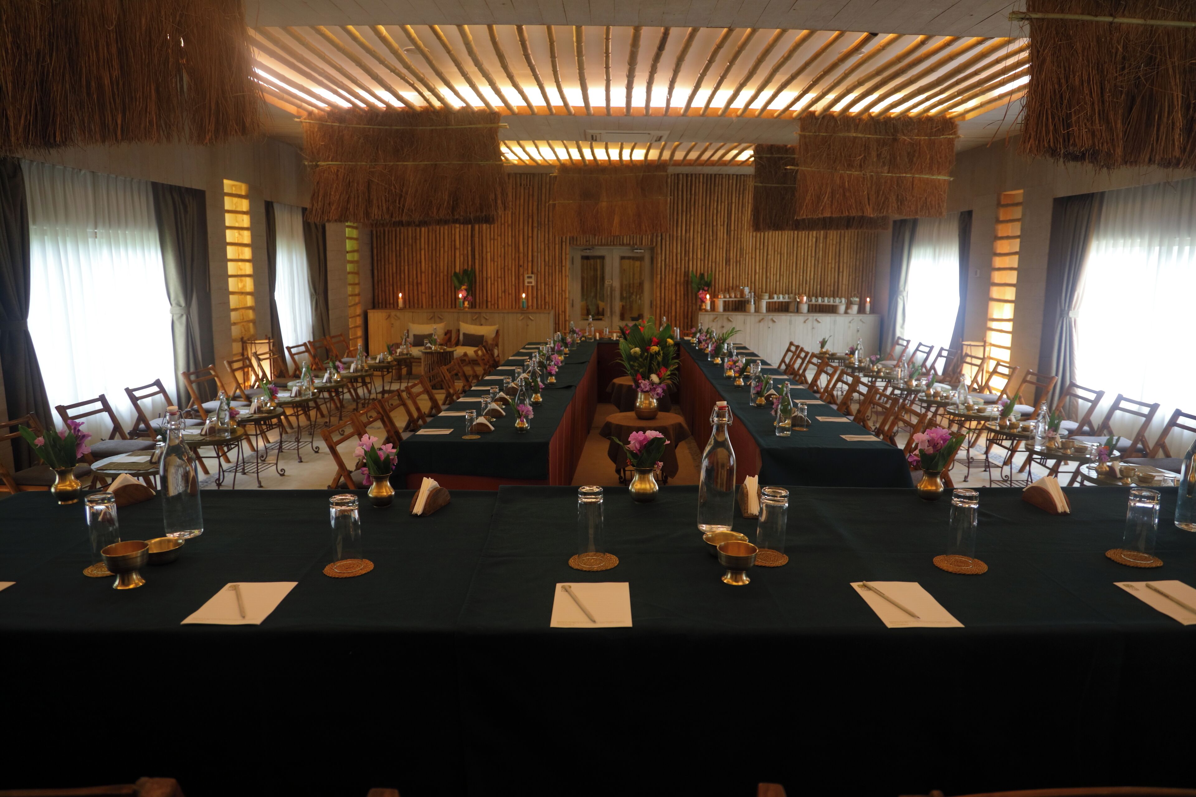 Un salón de conferencias con largas mesas, sillas y un pasillo central.