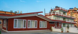 Un edificio de ladrillo rojo con ventanas de marco blanco y techo plano.