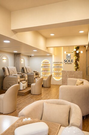 Un centre de bien-être équipé de fauteuils de massage, d’un comptoir d’accueil et d’étagères remplies de produits.