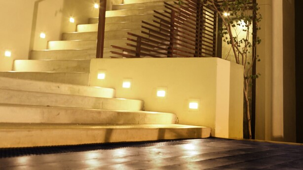 A staircase with wooden railings and a plant on the right. - Hotel Cloud Nine (Negombo)