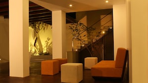 A modern interior with a staircase, wooden flooring, and orange upholstered seating. - Hotel Cloud Nine (Negombo)