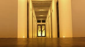 A long, narrow hallway with a wooden ceiling and a series of doors on either side. - Hotel Cloud Nine (Negombo)