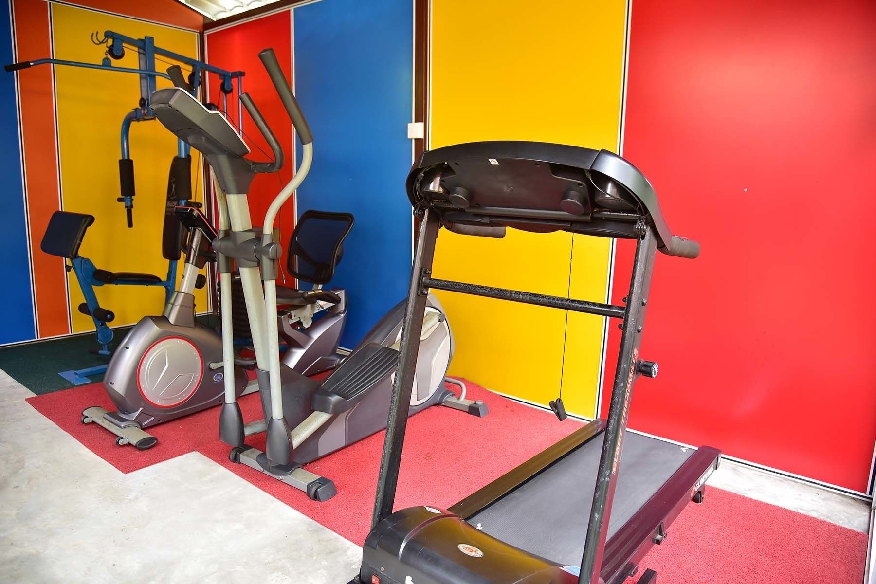 A gym with various exercise equipment, including a treadmill, stationary bike, and weight machines.
