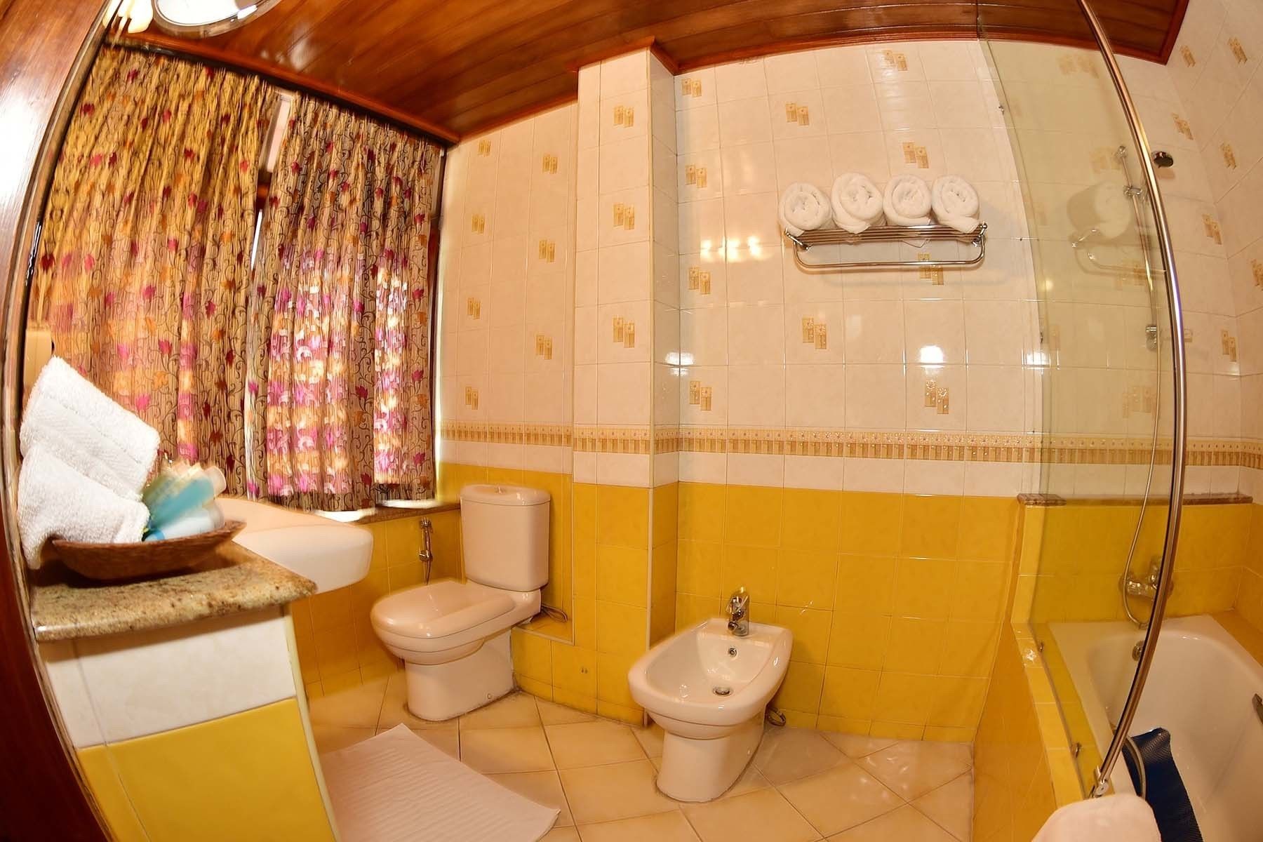 A bathroom with a toilet, bidet, and bathtub.