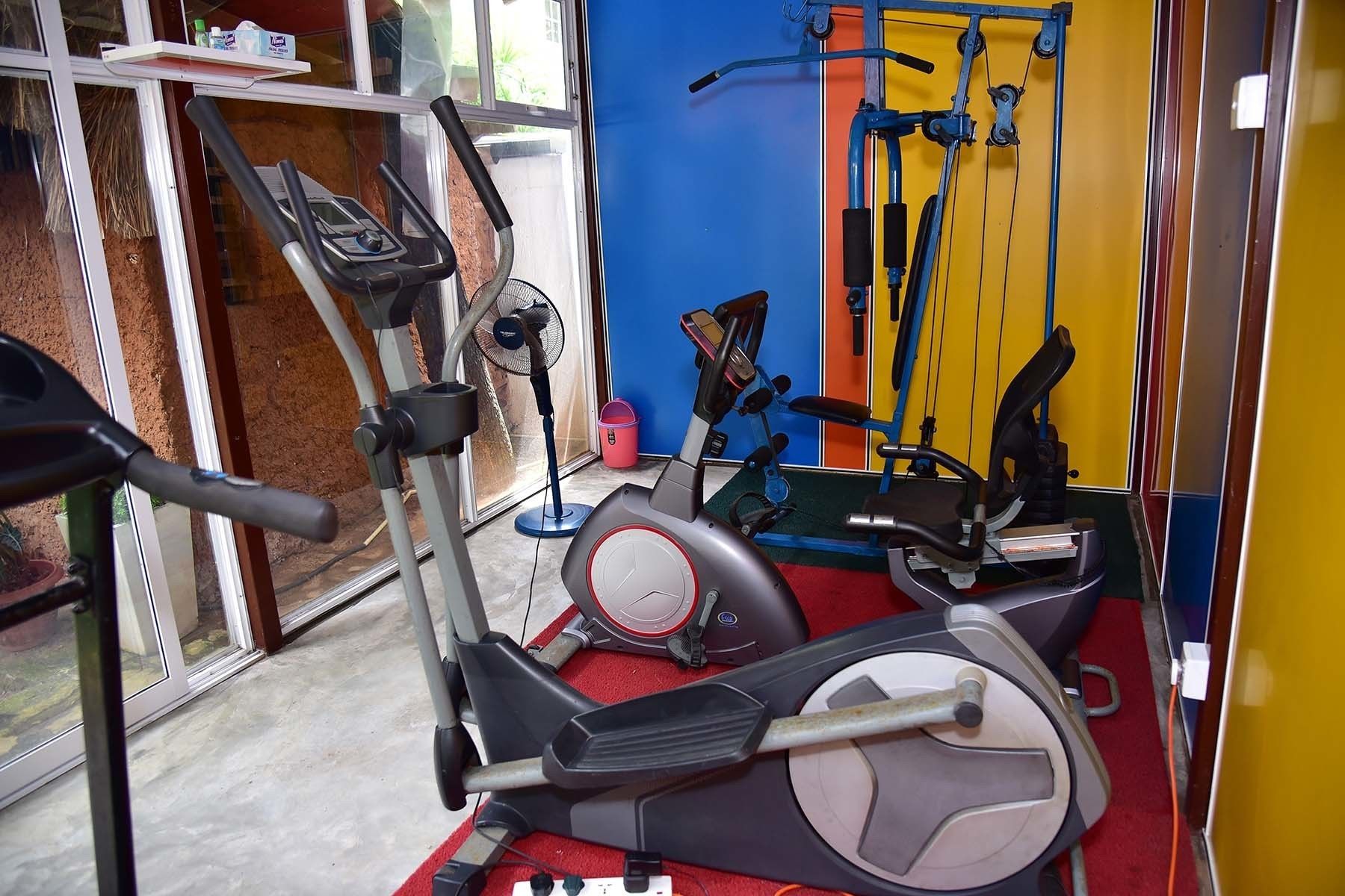 A gym with exercise equipment including a treadmill, stationary bike, and weight machines.