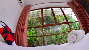 A hotel room with a large window, a bed, and a pillow. - Colombo Villa at Cambridge Place (Colombo)