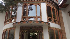 Un immeuble à plusieurs étages, doté de façades richement décorées et ornées de motifs, ainsi que de grandes fenêtres.