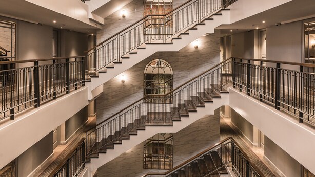 A multi-level interior with a central staircase, multiple balconies, and a grand chandelier. - The Salil Sukhumvit 57 - Thonglor (Bangkok)