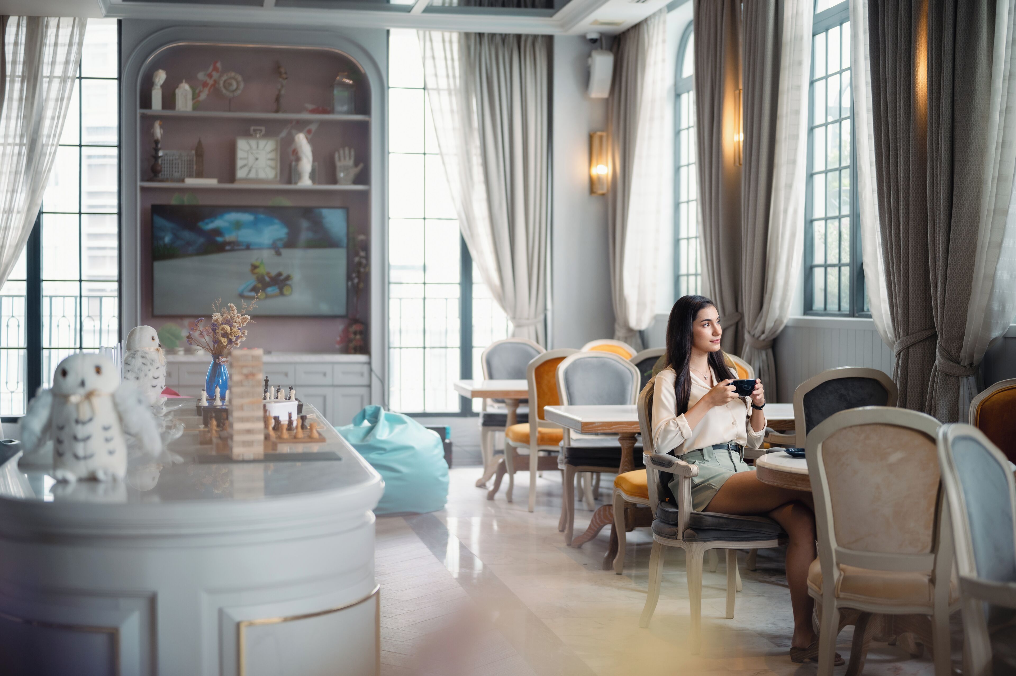 A cozy room with a chessboard, plush toys, and a television.