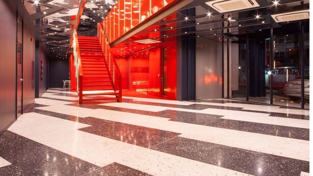 A modern interior with a prominent red staircase and geometric ceiling design. - Klub Hotel (Bangkok)